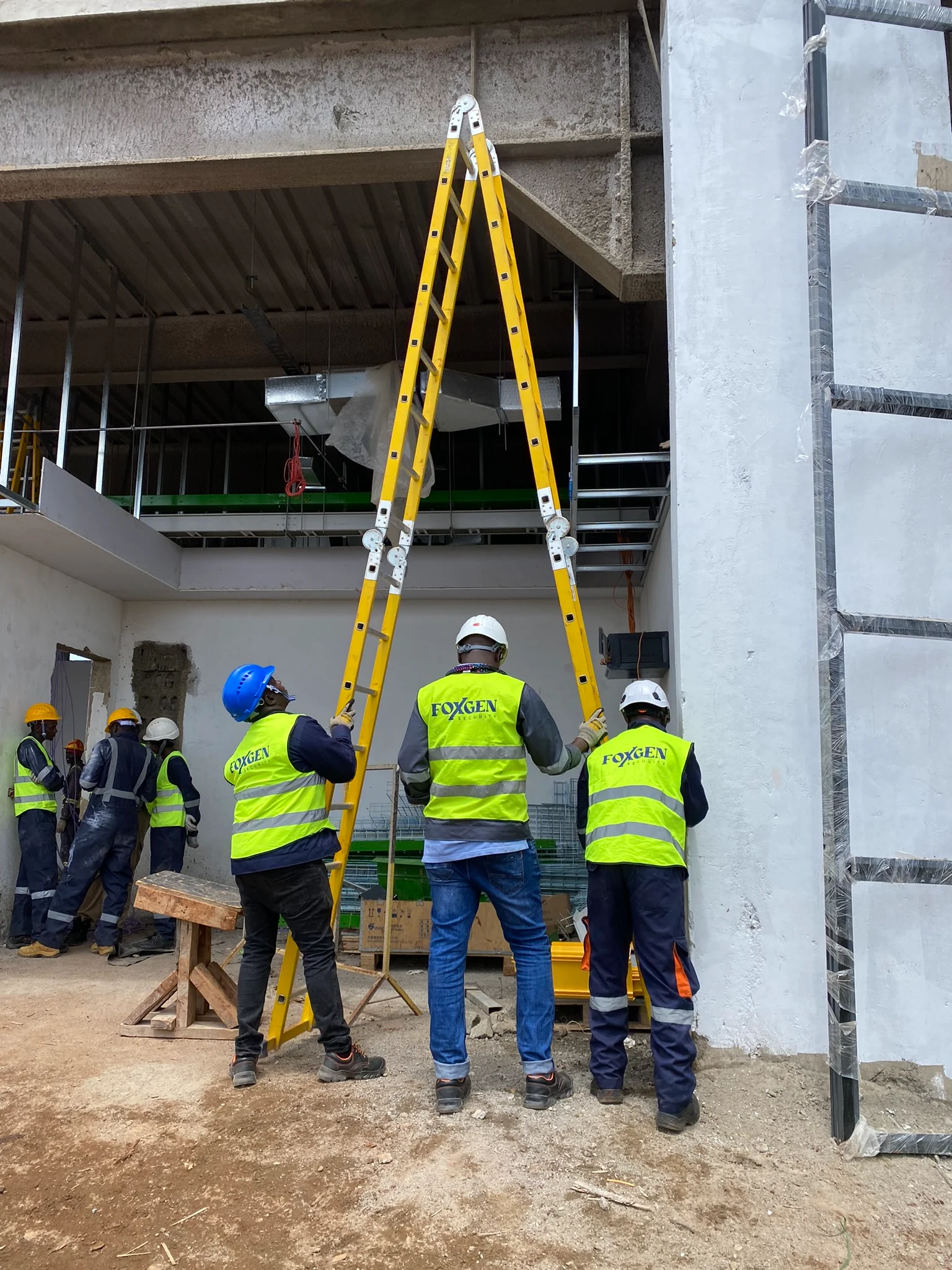 Foxgen installation team positioning a ladder inside a building under construction